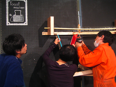 Masa Kimura, Aya Komori and Yuri Suzuki working on the toast machine